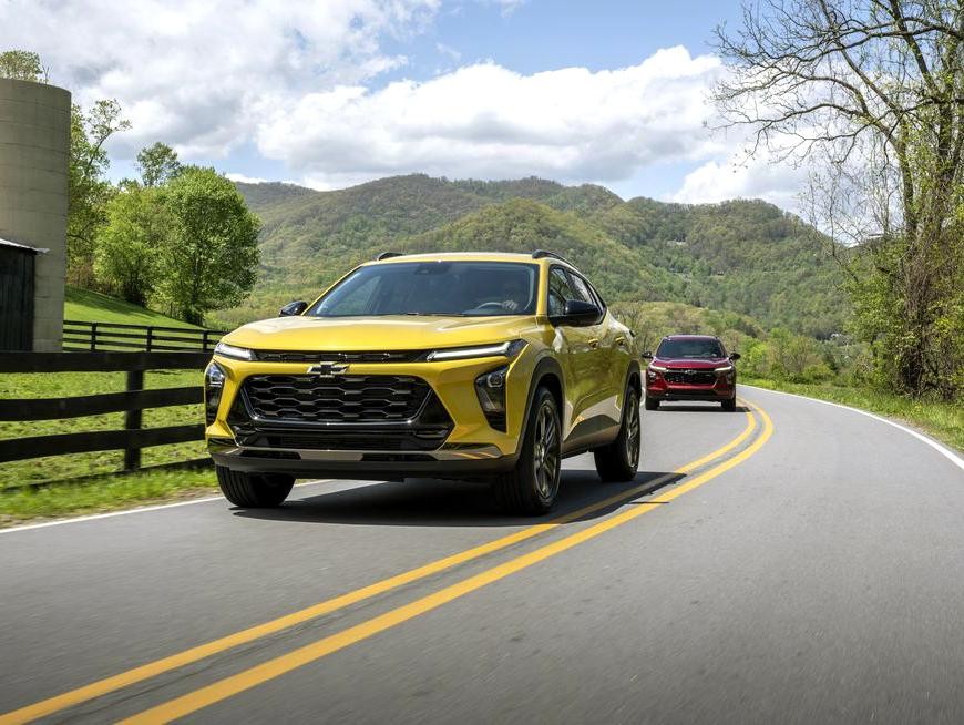 Yellow 2024 Chevy Trax driving in hilly terrain