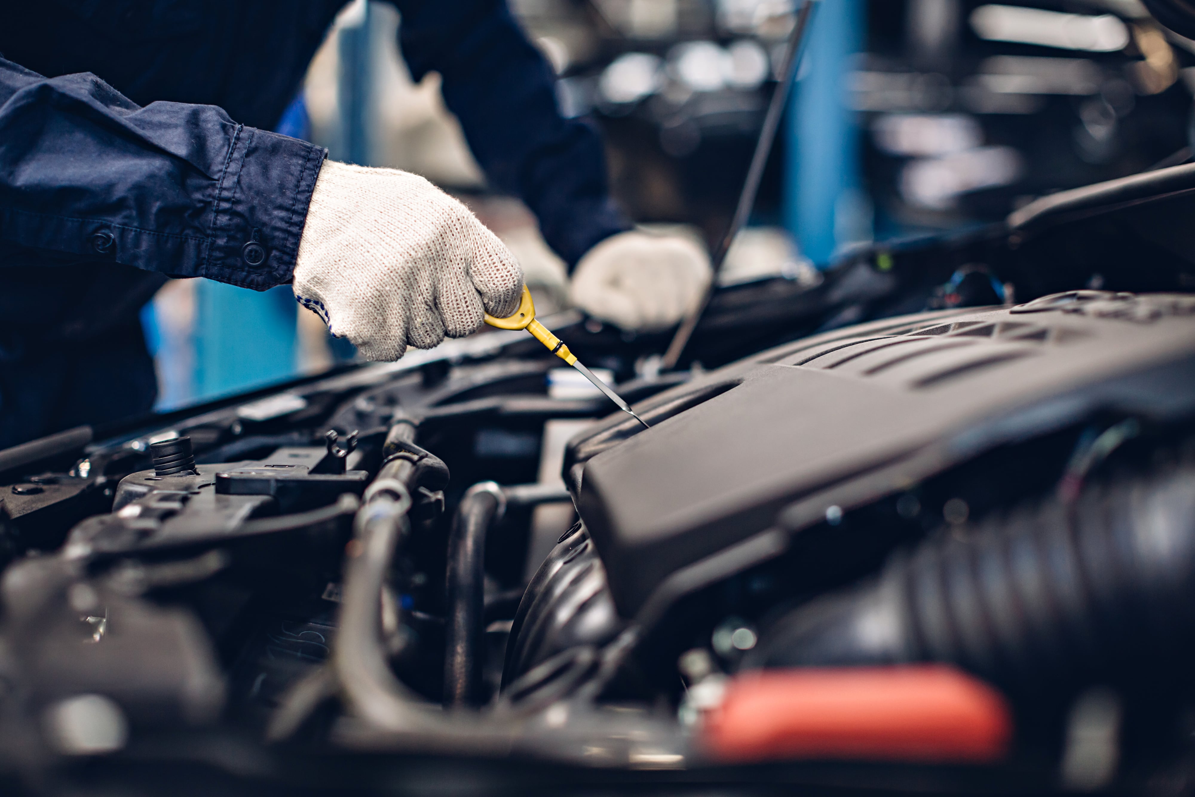 Mechanic checking the oil levels on an engine with a dipstick