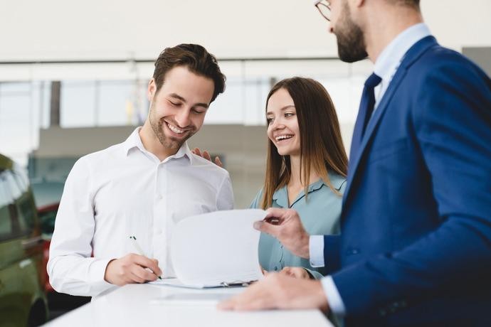 Young couple signing finance documents