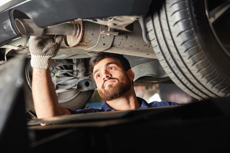 Smiling service mechanic working on an engine