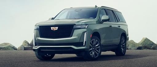 Cadillac 2024 Escalade Sport Platinum 4WD in Dark Emerald Metallic (G6N); Interior color is Whisper Beige with Gideon Accents; 6.2L V8 engine (L87); 22" 12-Spoke alloy wheels polished with Dark Android finish 3/4 driver side front view