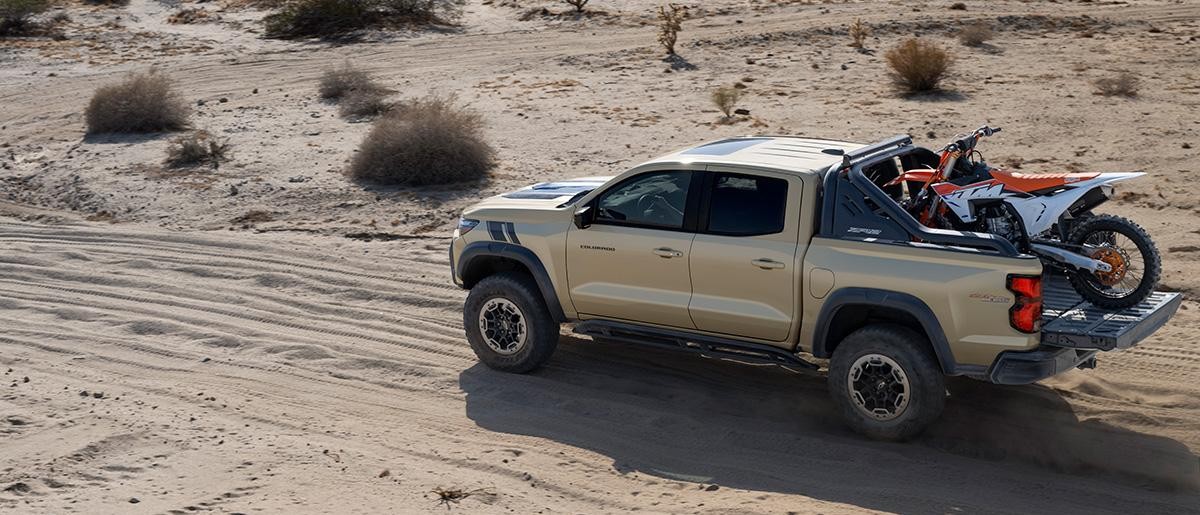 2023 Colorado on a sandy road with a dirt bike in the truck bed