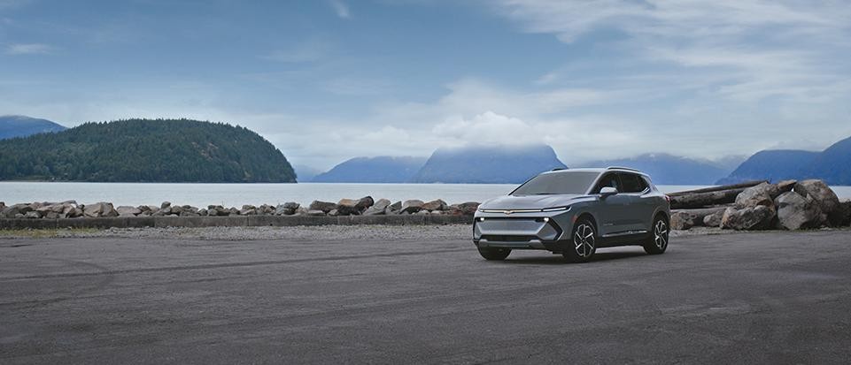 Chevrolet Equinox EV parked in front of a lake and mountains