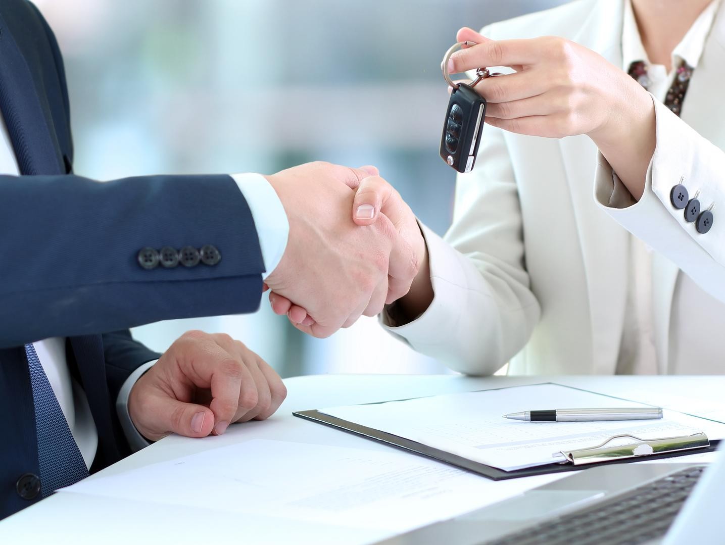Couple in a dealership with a salesman and car keys