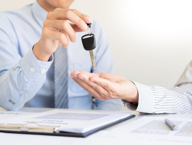 Car-salesman-handing-keys-to-customer