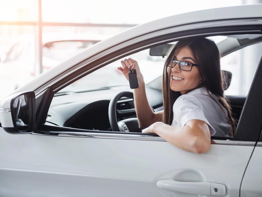Woman holding the keys to her newly purchased used car