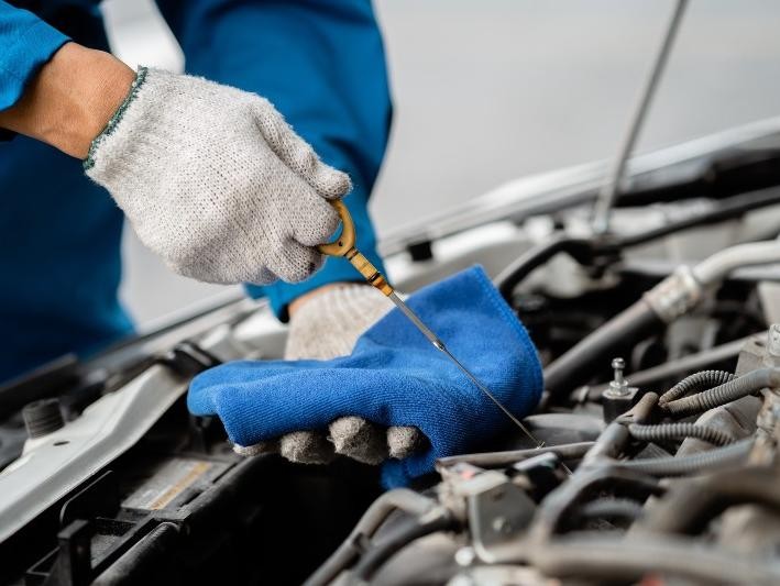 mechanic checking oil at Lawrence Chevrolet