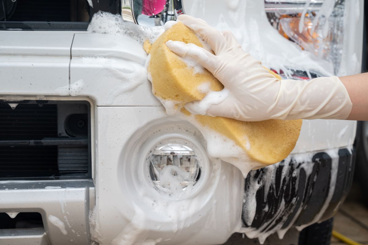 Sponge being used to wash a car