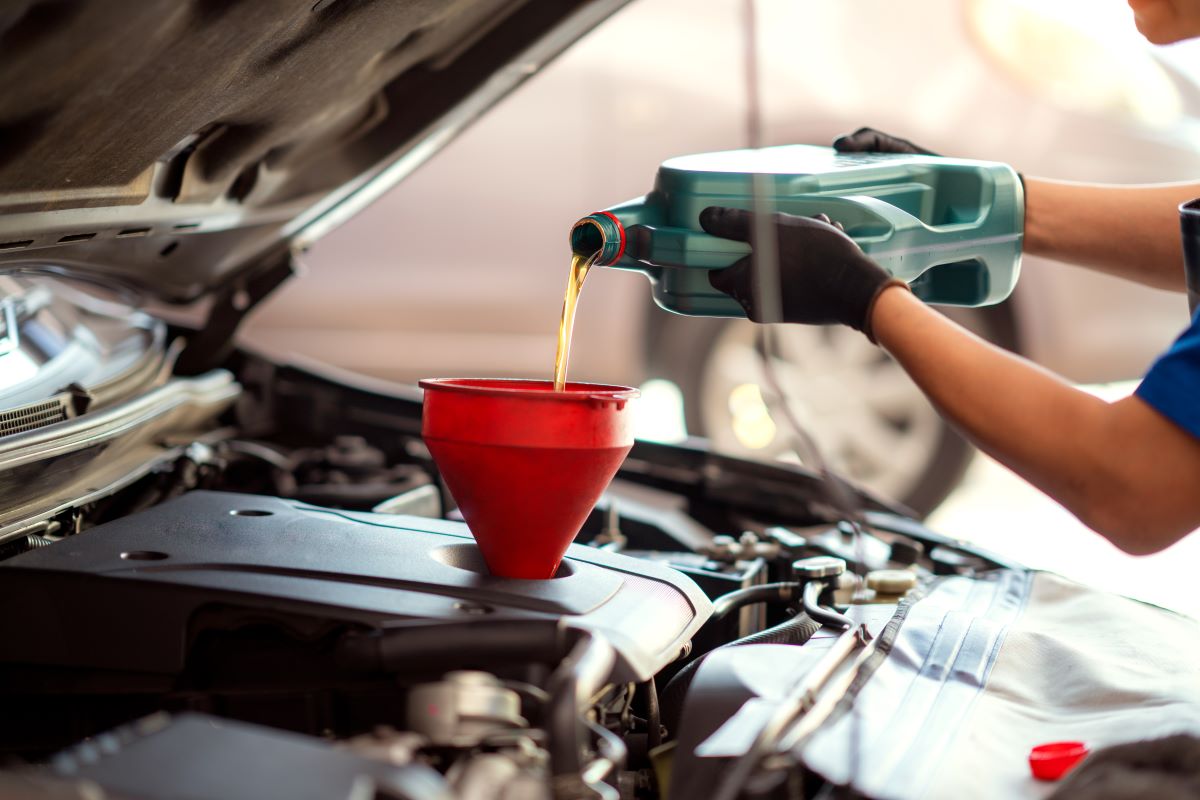 Mechanic adding oil to a car