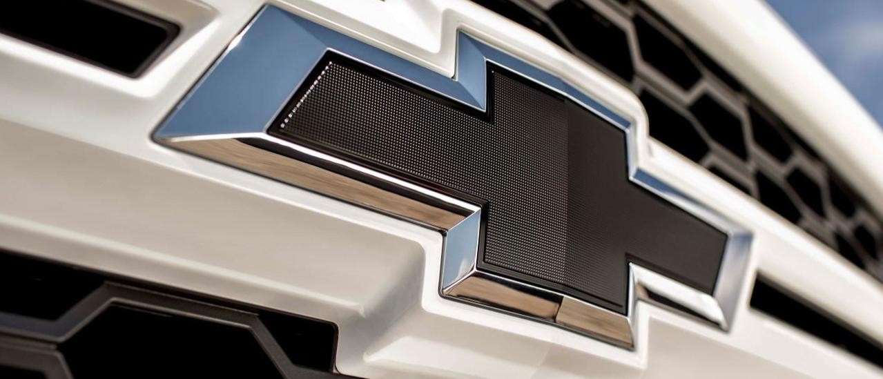 A close up shows the Chevy badge on a white 2015 Chevy Silverado1500 Rally Edition.