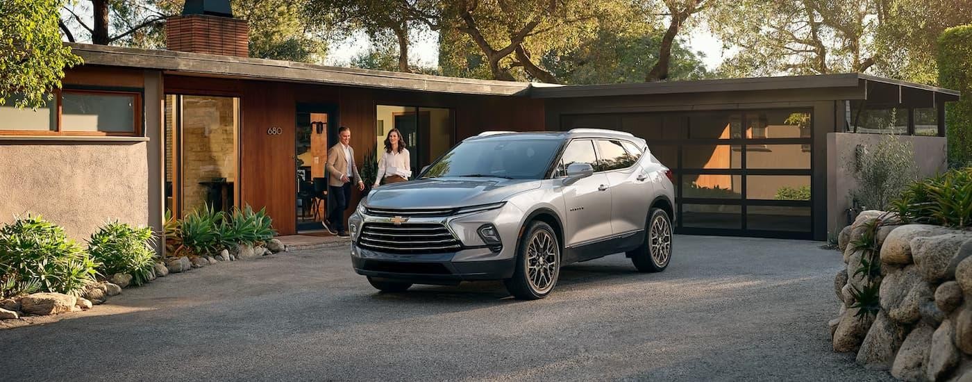 A grey 2024 Chevy Blazer, a popular Chevy SUV for sale, is shown parked in a driveway.