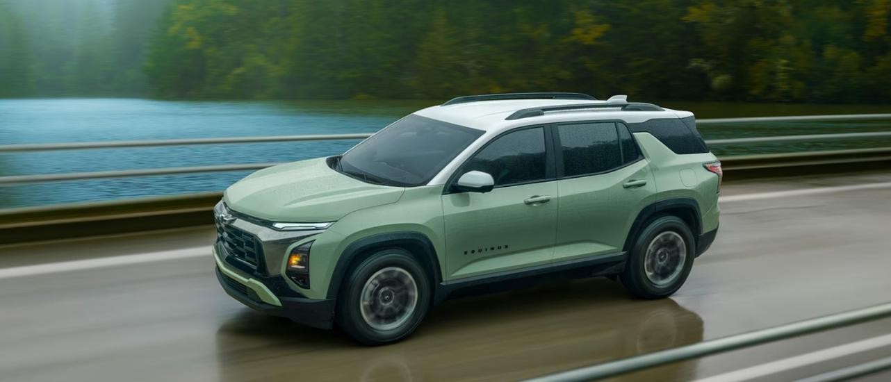 A green 2025 Chevy Equinox ACTIV is shown driving on a bridge.