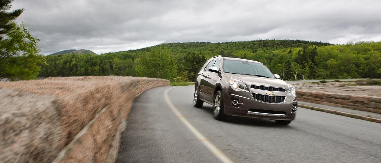 A tan 2012 Chevy Equinox LTZ is shown rounding a corner.