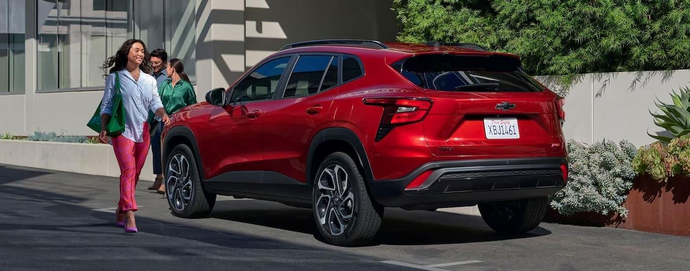 A red 2024 Chevy Trax RS is shown from a rear angle parked on the side of a street.