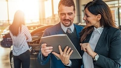 Dealership associate helping a man with his vehicle purchase