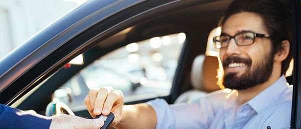 Man taking the keys to his new car with swapping keys icon