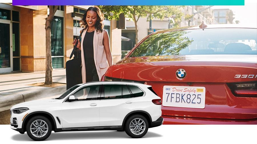 Woman walking beside a red BMW with a white X5 in the forefront