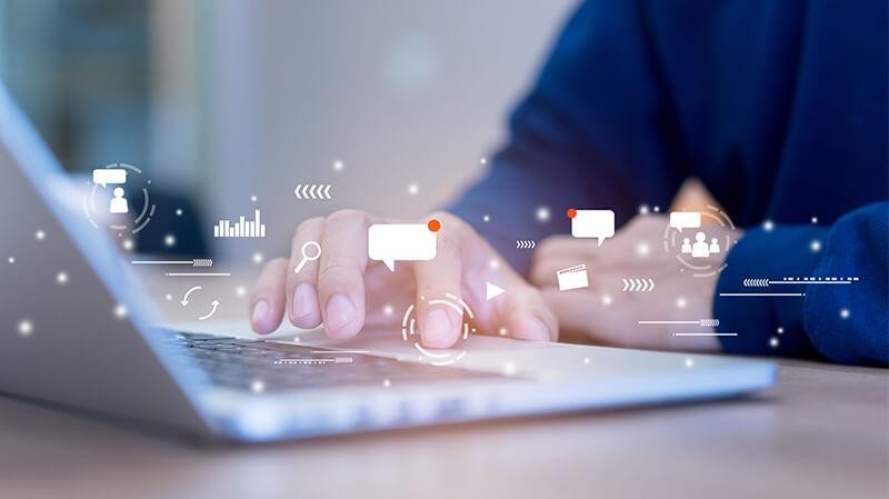 Man using a laptop with marketing icons