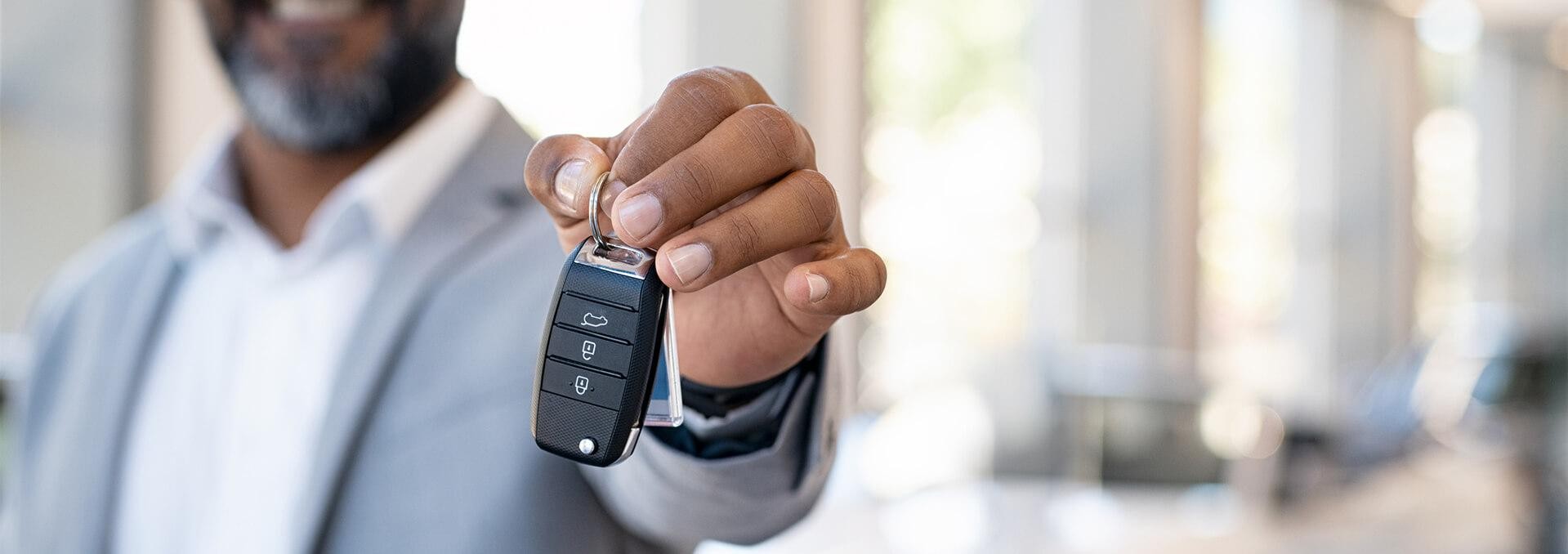 Man holding keys inside dealerships 