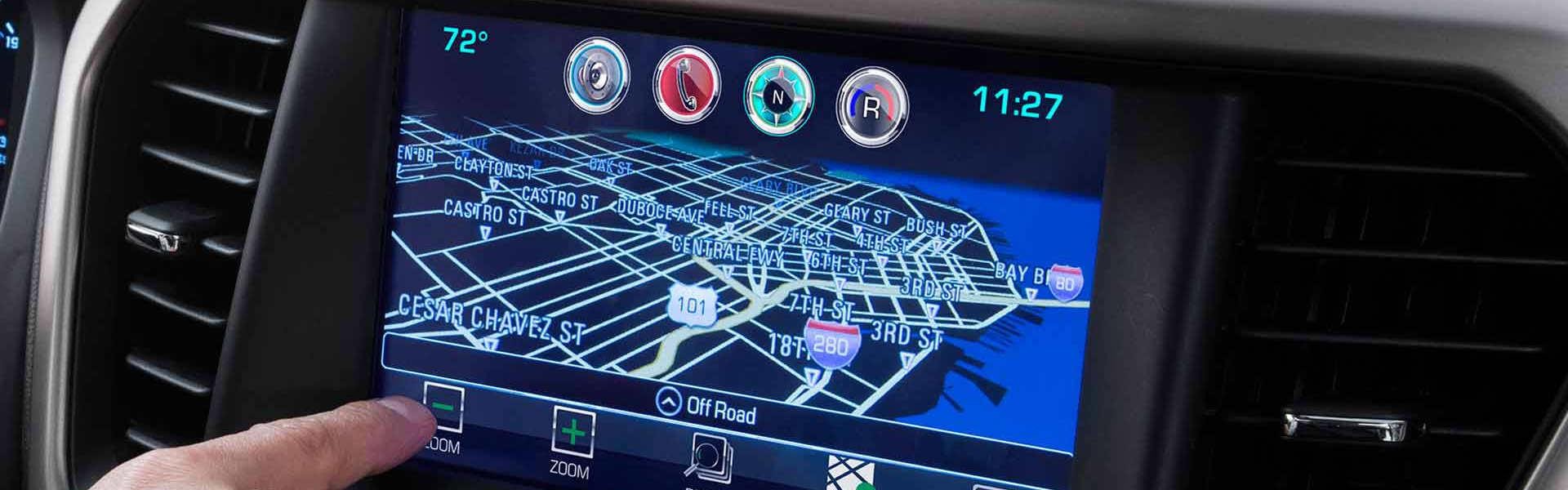 Man touching the zoom feature in a 2018 GMC Acadia