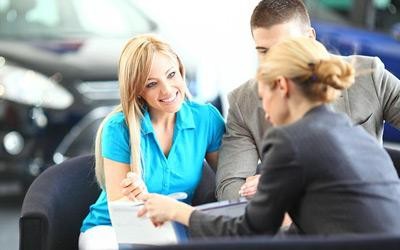 Woman at a customer service desk helping the customers with a transaction.