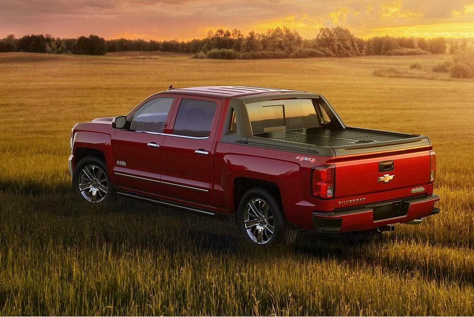 A red 2018 Chevy Silverado 1500 driving through a grassy field