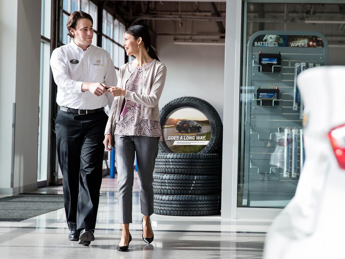  Certified Service Employee handing keys to women.