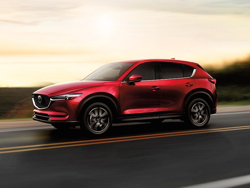 2017 Mazda CX-5 driving on a road with sunset on the background.
