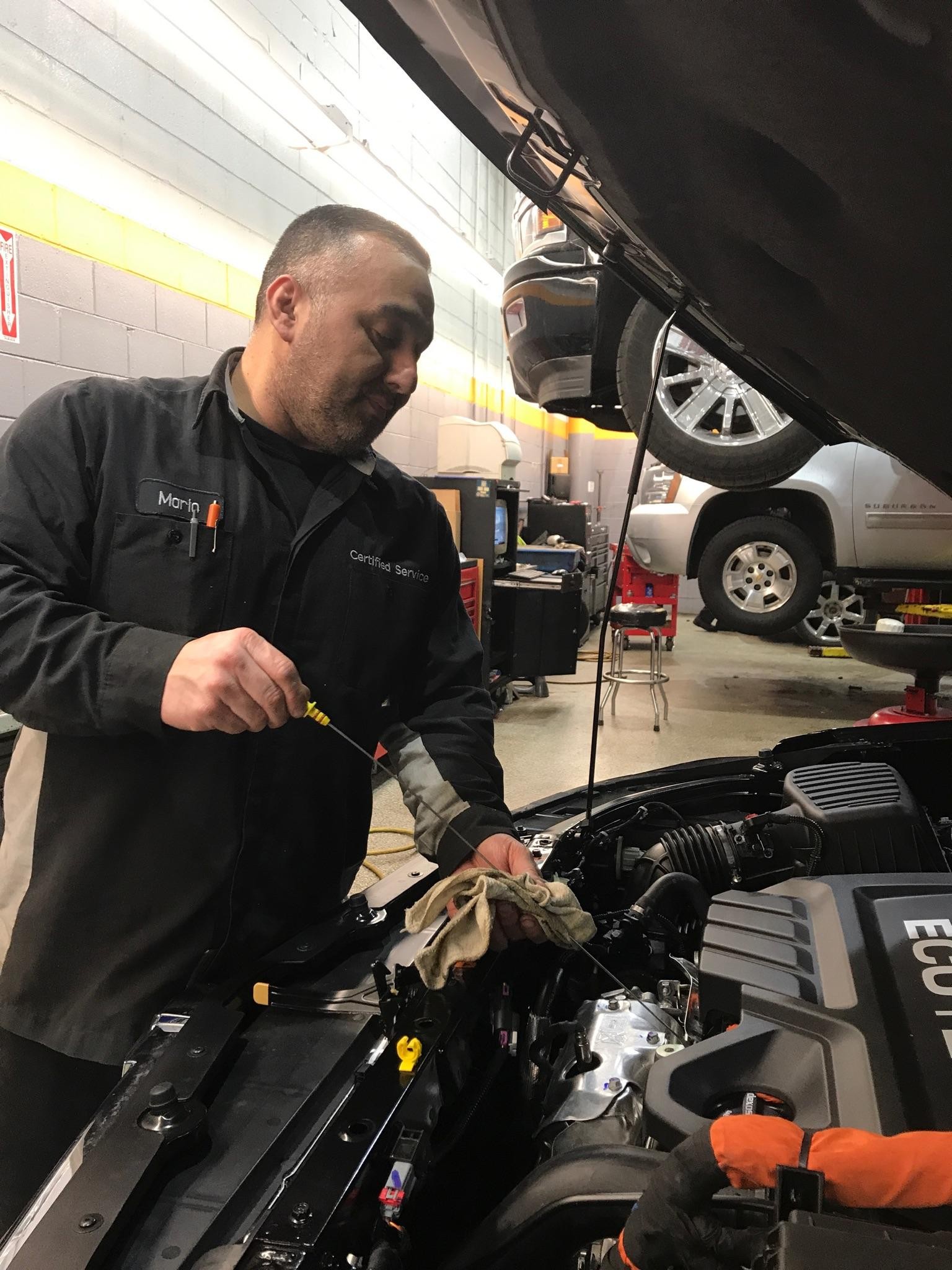 Service technician checking vehicle oil
