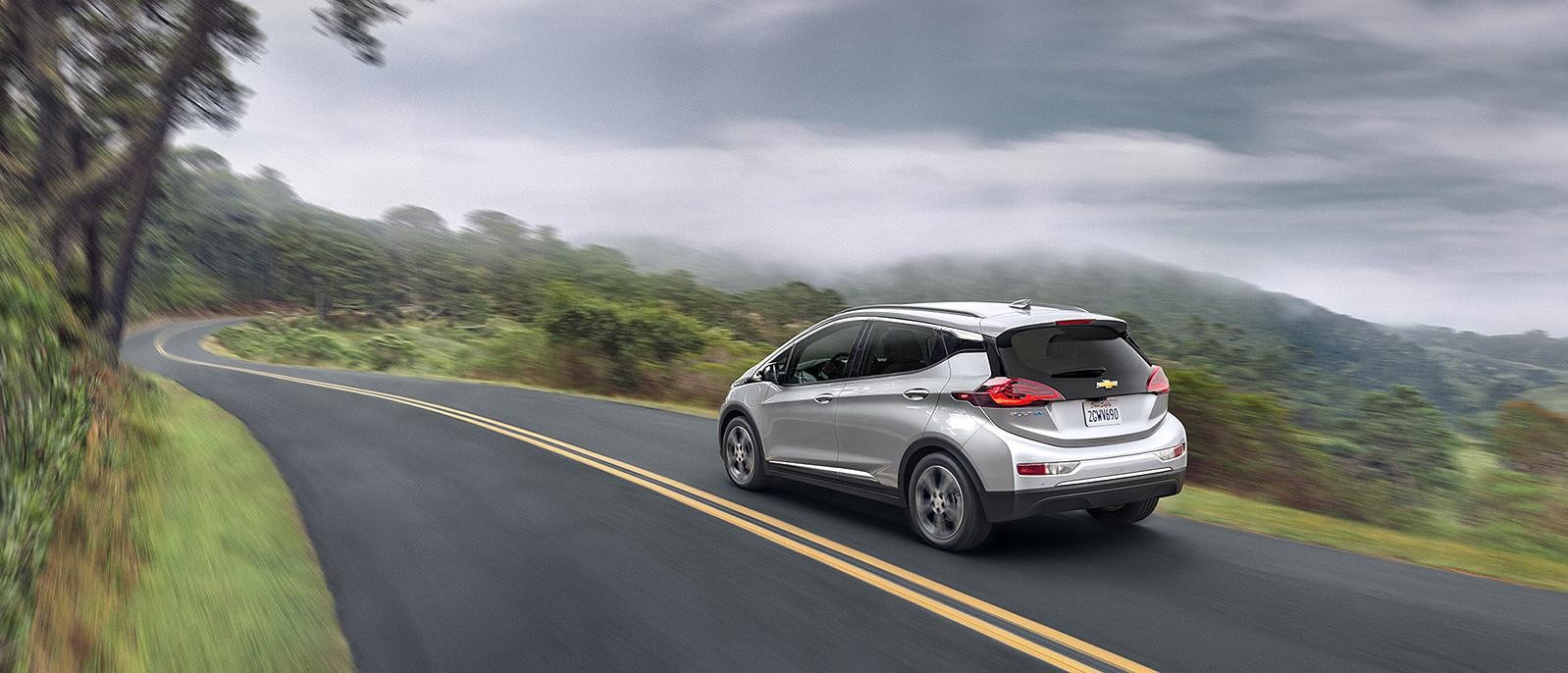 The 2018 Chevy Bolt EV driving along a scenic highway.