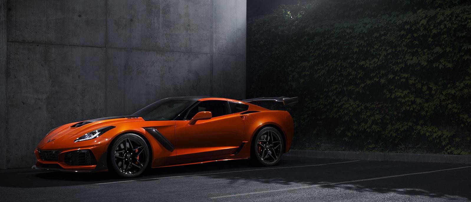A Sebring Orange 2019 Chevy Corvette parked in a pool of moonlight.