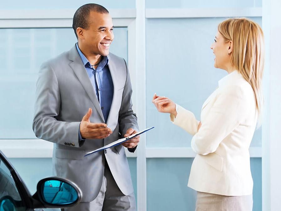 Woman Chatting with Salesperson in Dealership Showroom