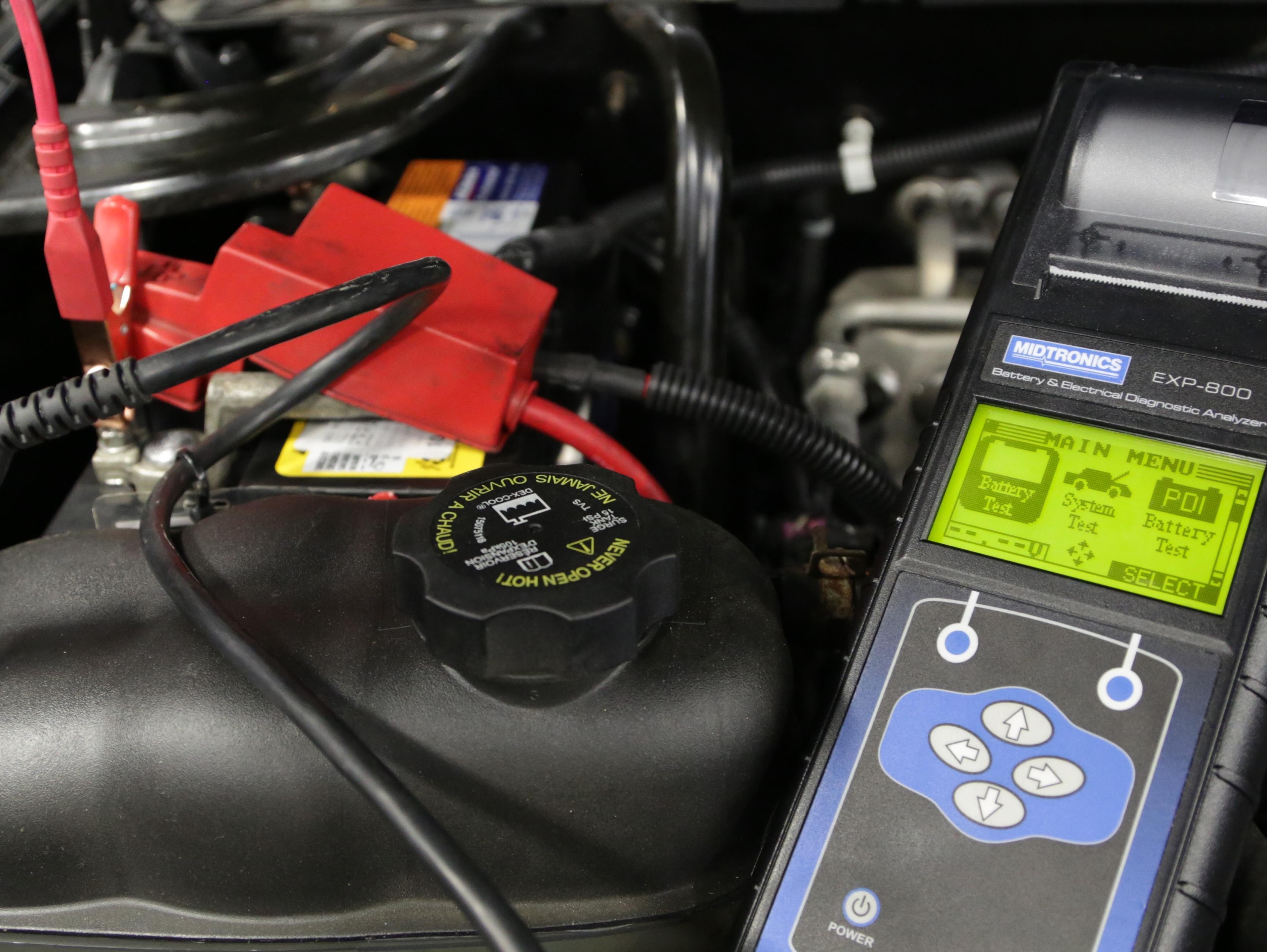 Service technician changing vehicle battery