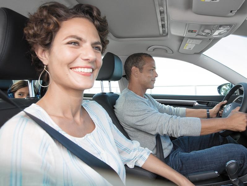 Happy couple driving in Volkswagen Passat