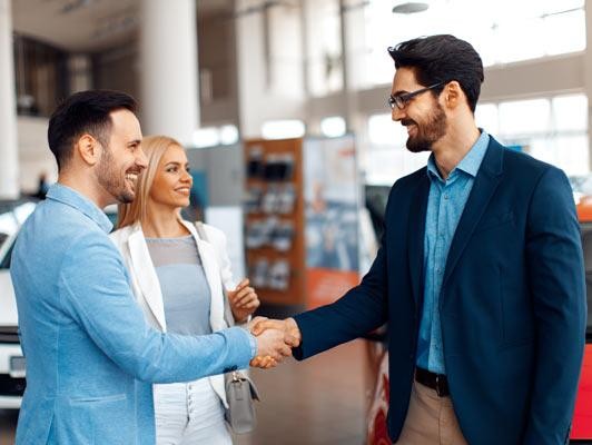 Young couple shaking hands after a successful car buying