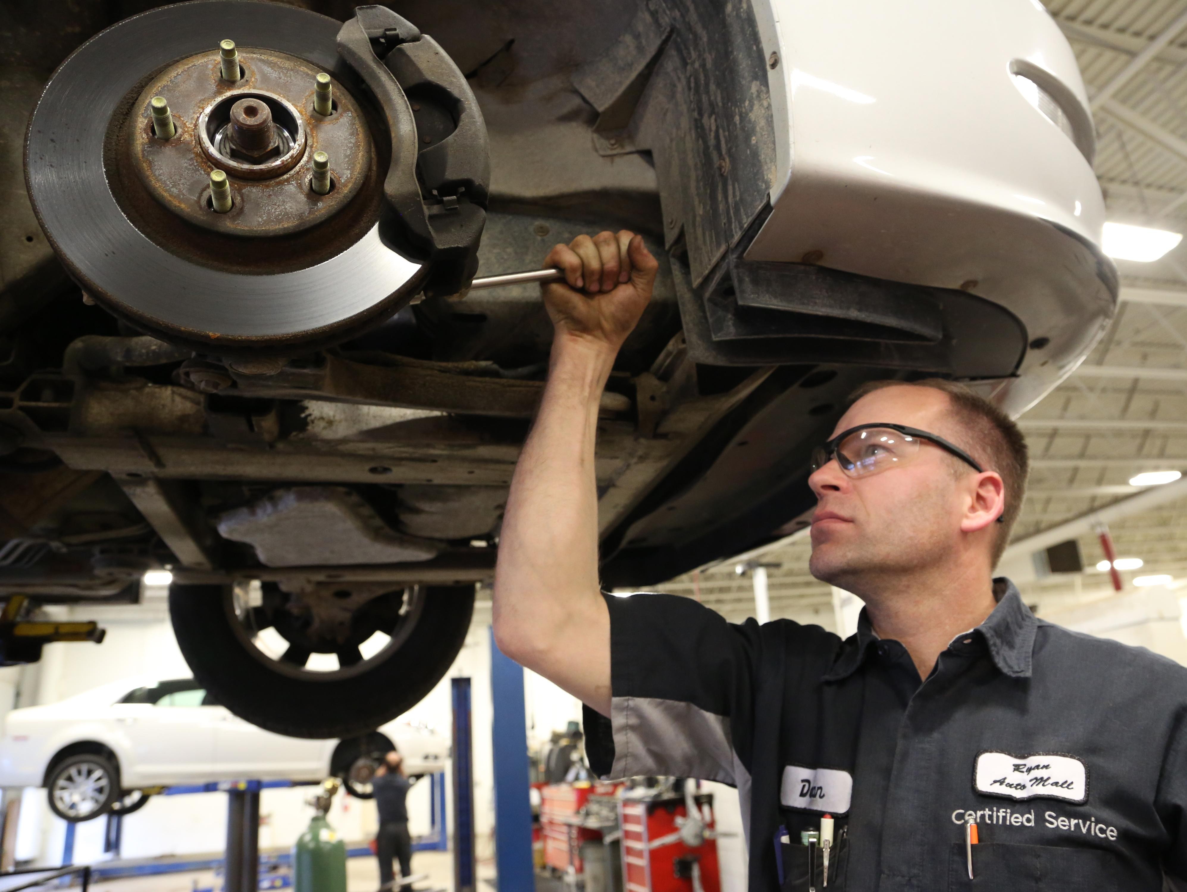 Service technician changing brake pads