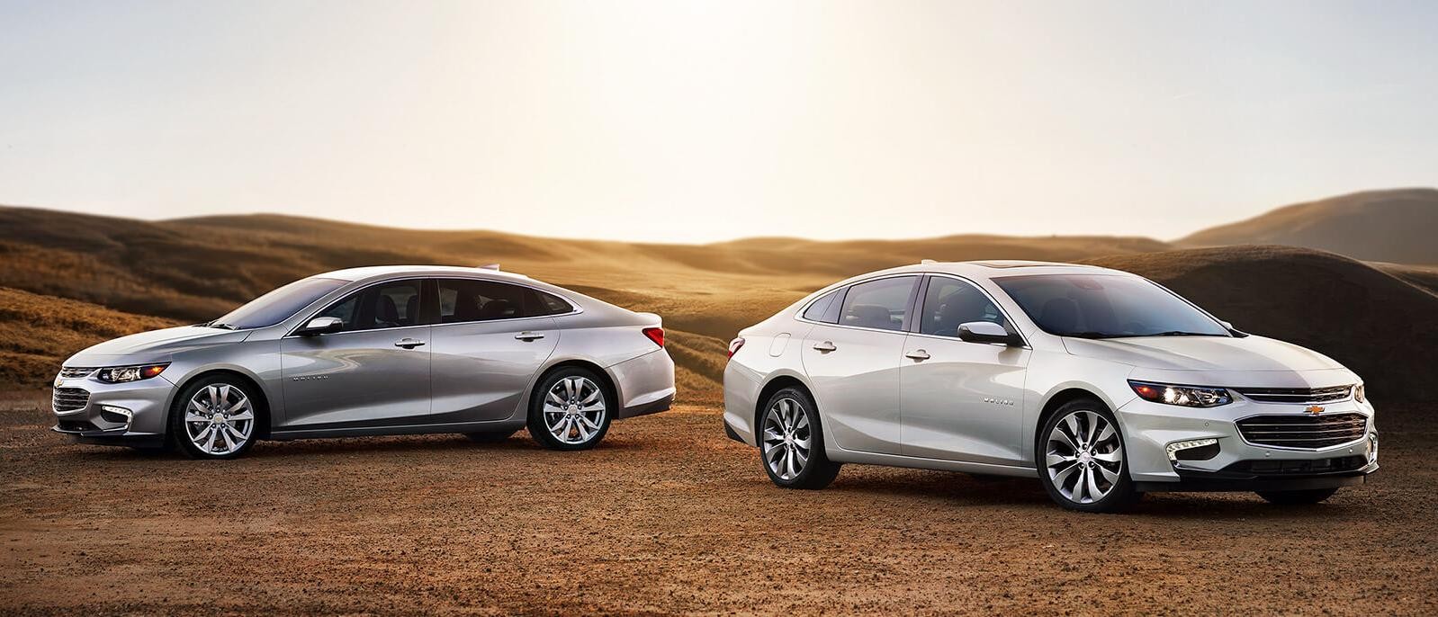 A 2018 Chevy Impala LT and Premier in a field.