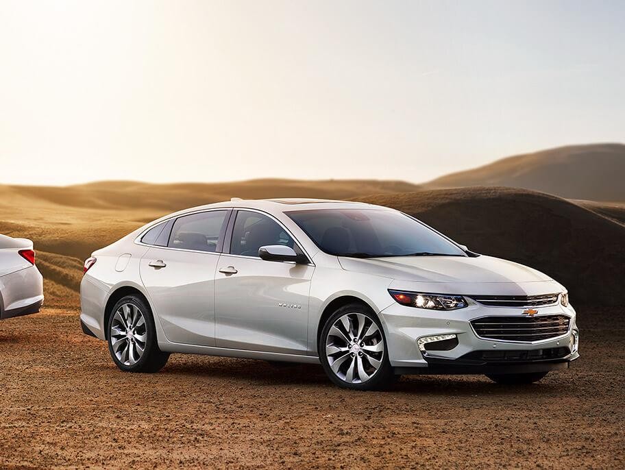 A 2018 Chevy Impala LT and Premier in a field.