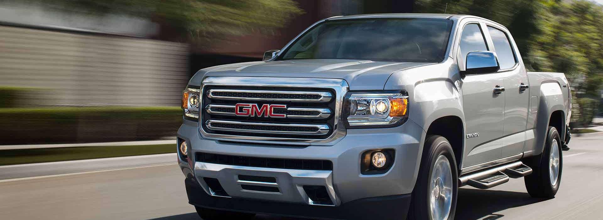 A silver 2018 GMC Canyon driving along a city road