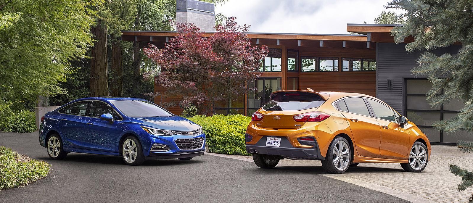 2018 Chevy Cruze Hatch and Sedan parked in a driveway.