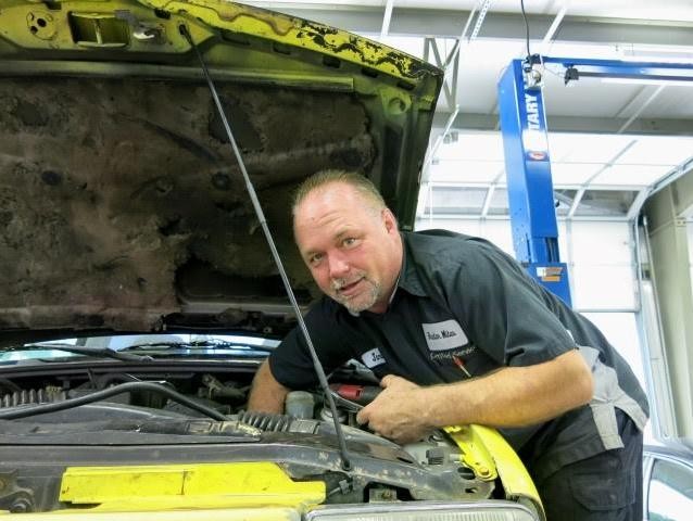 Service technician checking vehicle oil