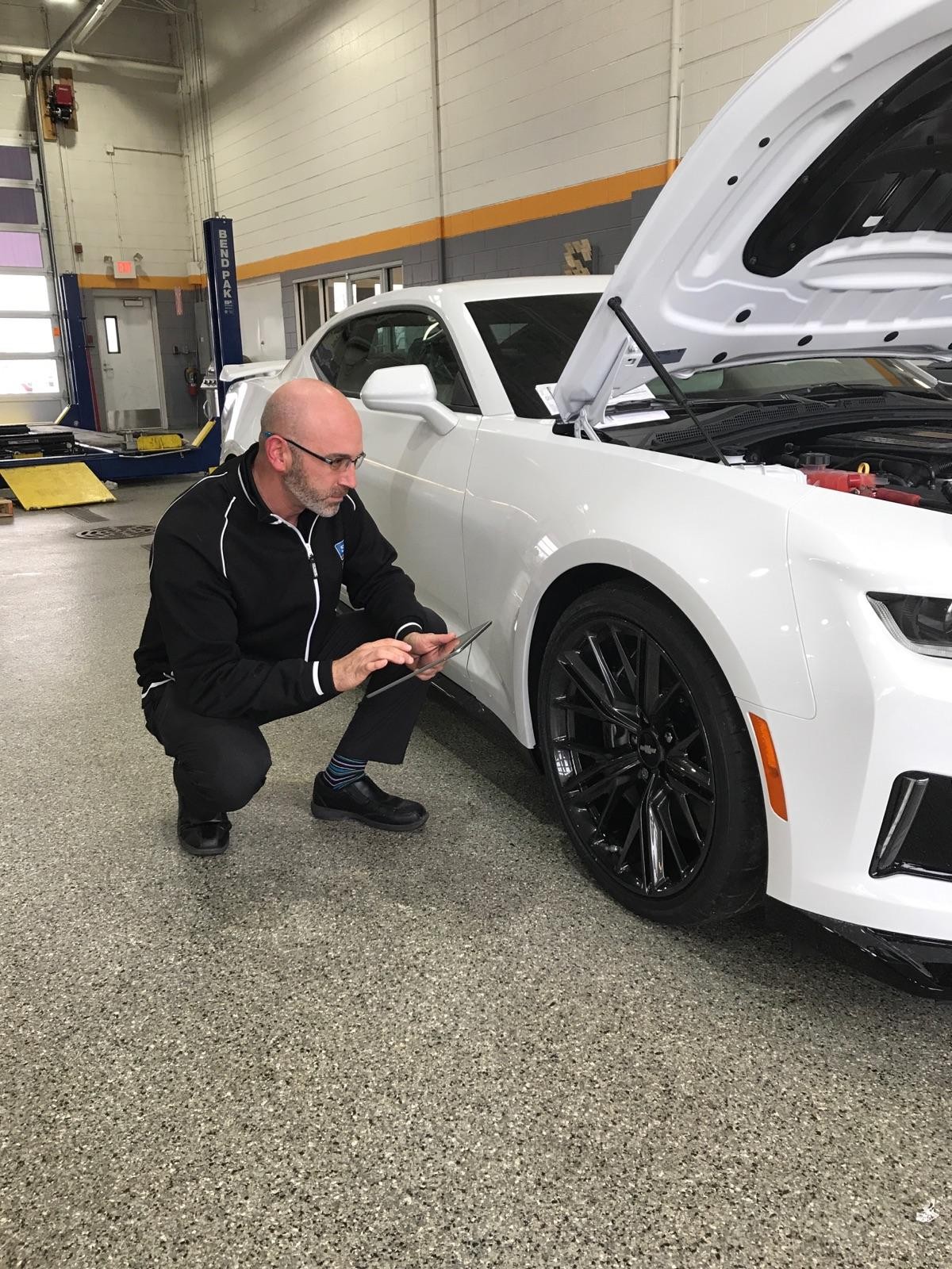 Chevrolet Service technician checking on tires of SUV