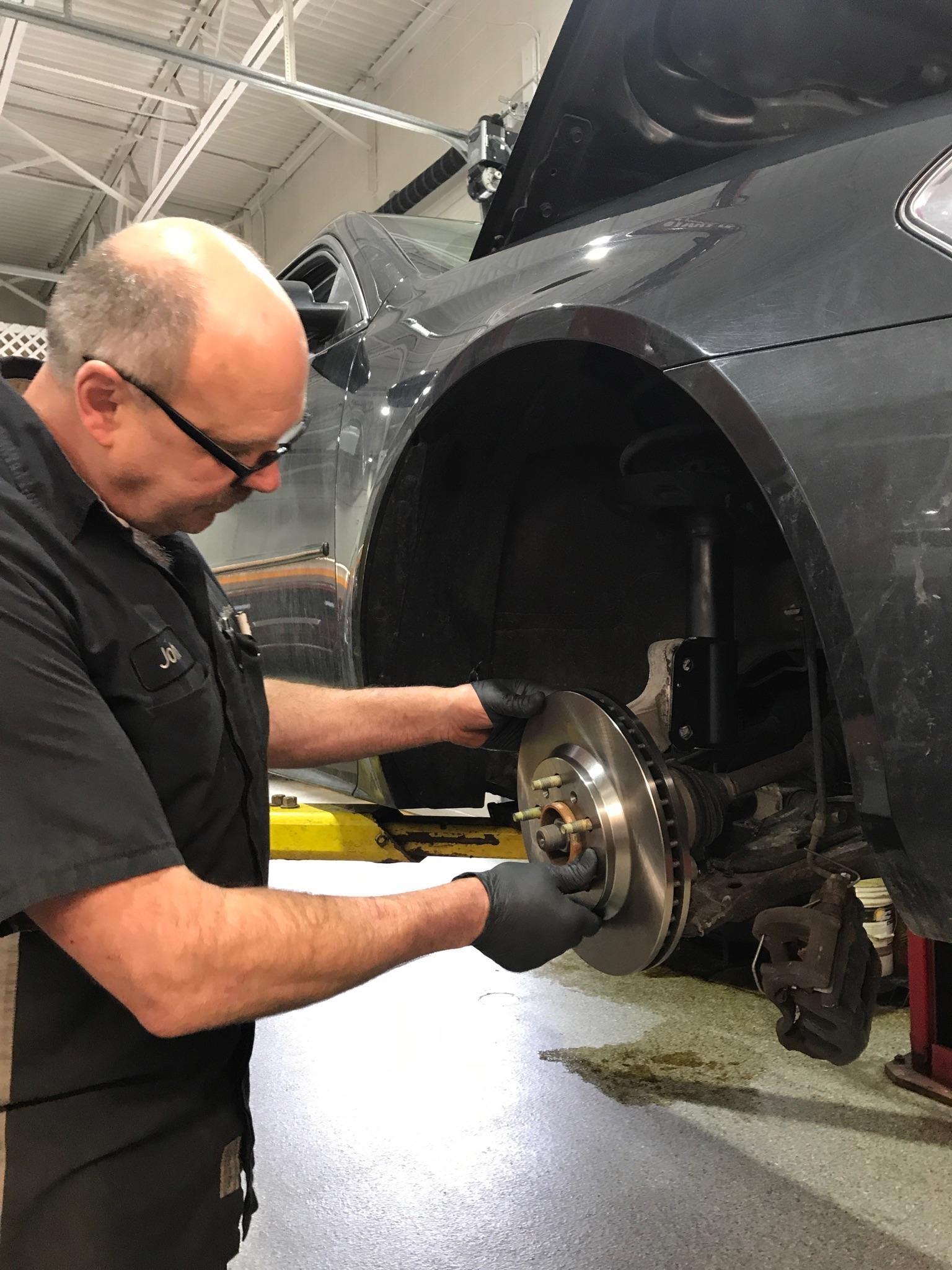 Service technician changing brake pads