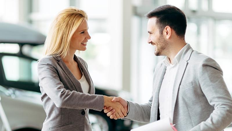Man closing a car deal with woman.
