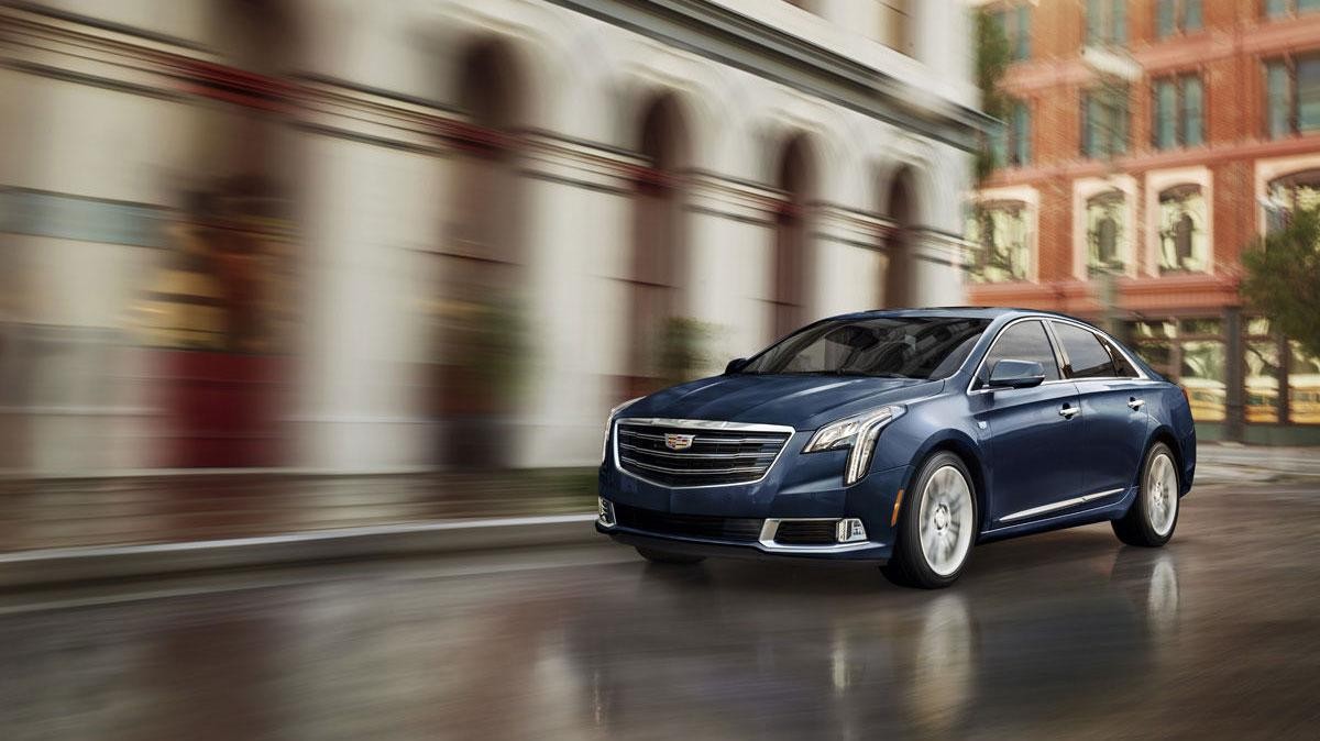 2018 Cadillac XTS Sedan driving down city street. 