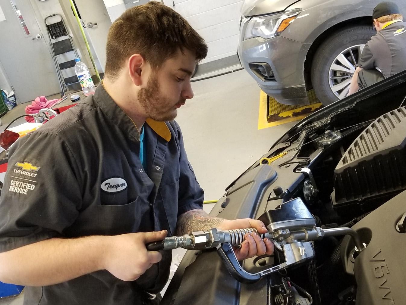 Service technician checking vehicle oil