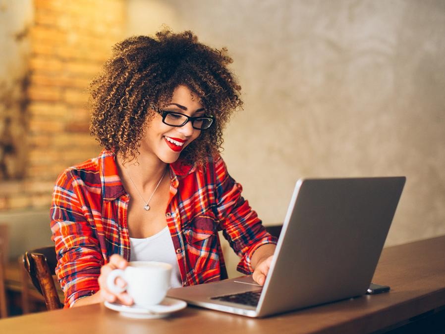 Woman at a cafe looking at her laptop computer.