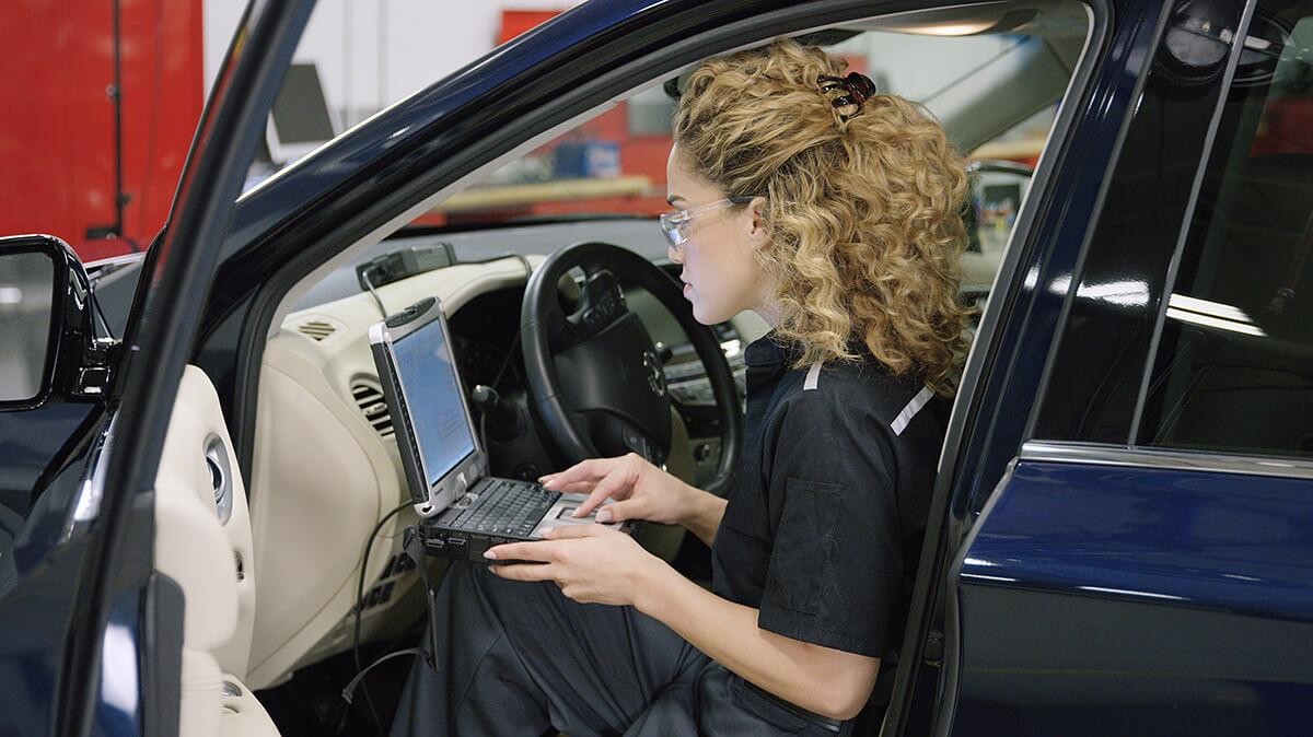 Infiniti technician performing diagnostics on vehicle.