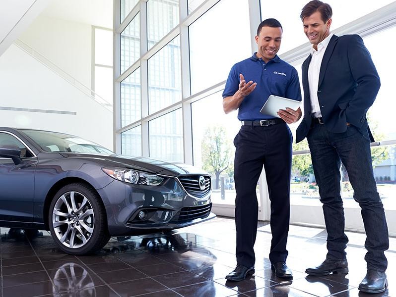 Mazda sales team showing customer their car value.