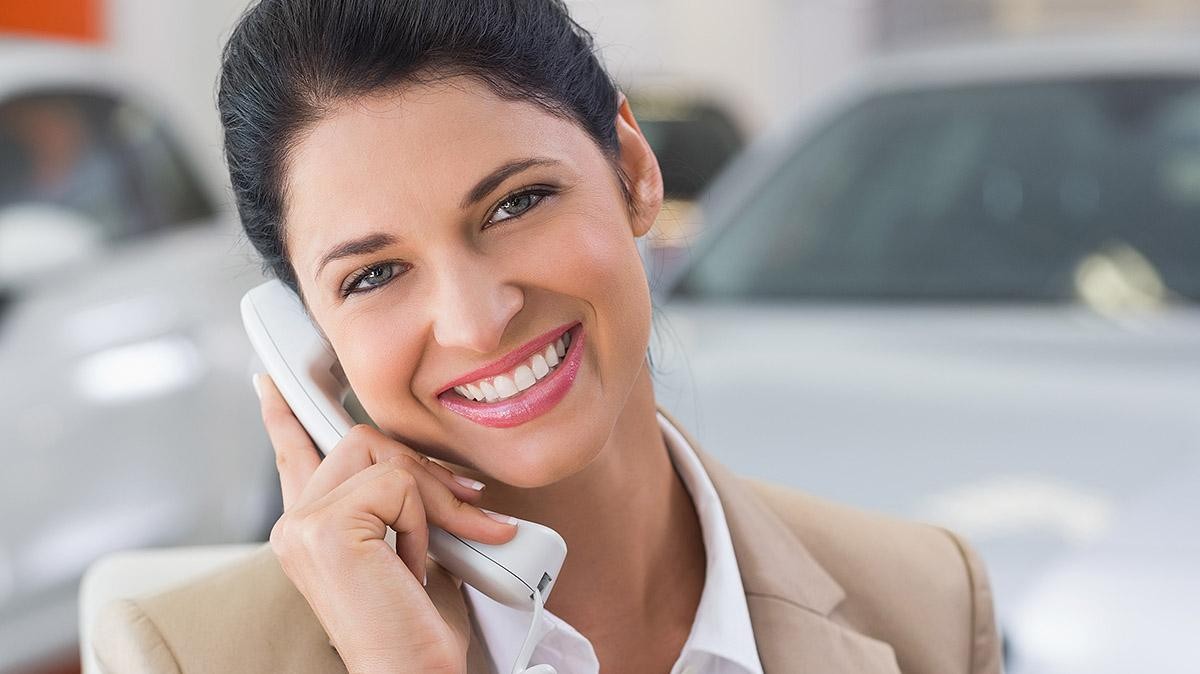Smiling Women at dealership on phone Smiling Women at dealership on phone